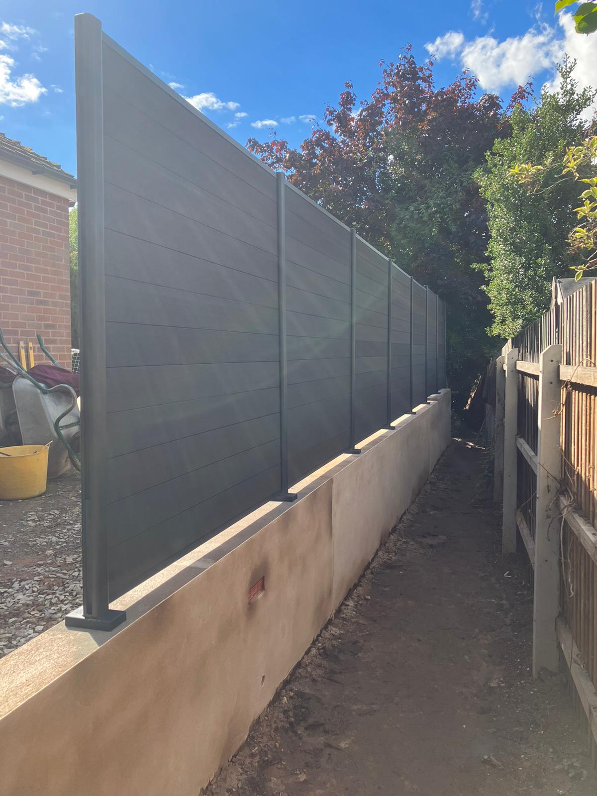 Bolt down composite fencing installed on a small garden wall