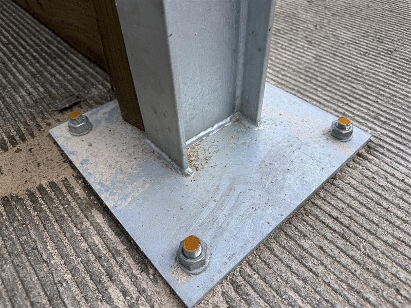 Bolted down post with rust on the tops of the bolts