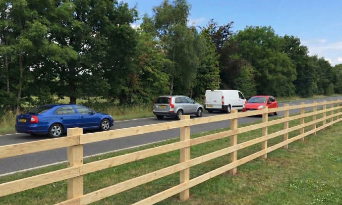 Highway post and rail fencing installed on a county road