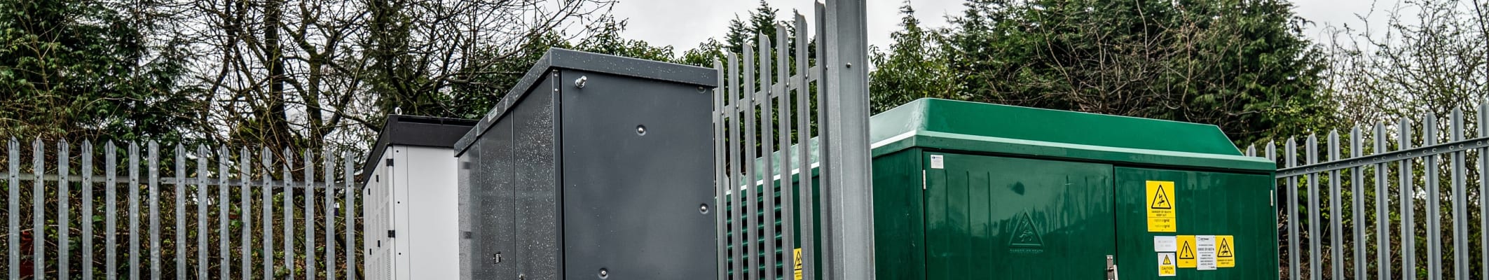 Non-conductive palisade fencing around a generator