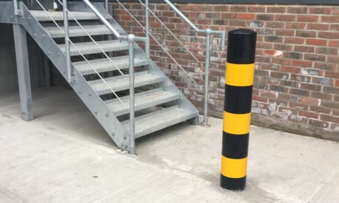 Black and yellow bollard installed near an outdoor staircase