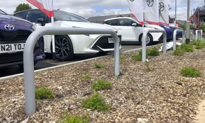 Cars parked with a hooped barrier installed in front to protect pedestrians