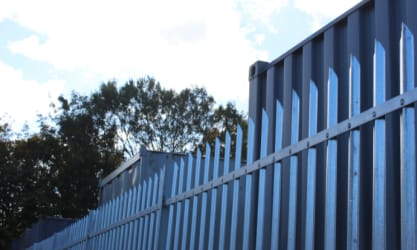 Palisade fencing installed near shipping containers
