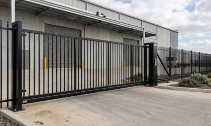 Sliding vertical bar gate and fencing outside a warehouse