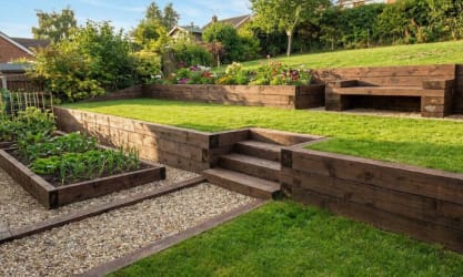 Railway sleepers installed in a garden as steps, retainer walls, and flower beds
