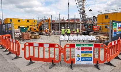 Construction site with safety barriers, PPE, and health and safety signage