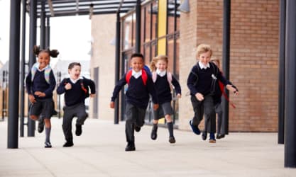 Happy children running through school