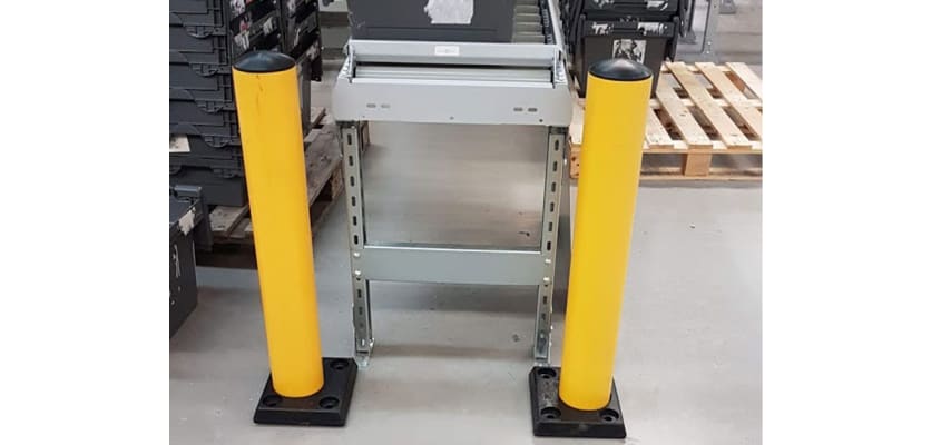 Two yellow protection posts in a warehouse