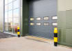 Two yellow and black bollards protecting a warehouse door