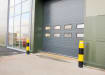 Two yellow and black bollards protecting the entrance to a warehouse