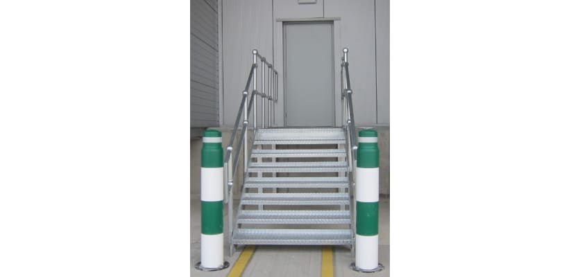 Two green and white bollards at the base of stairs