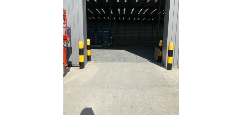 Front View of bollards installed around a warehouse loading door