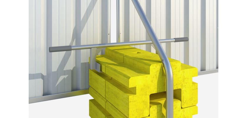 Two ballast blocks installed on hoarding fencing with lifting tool attached.
