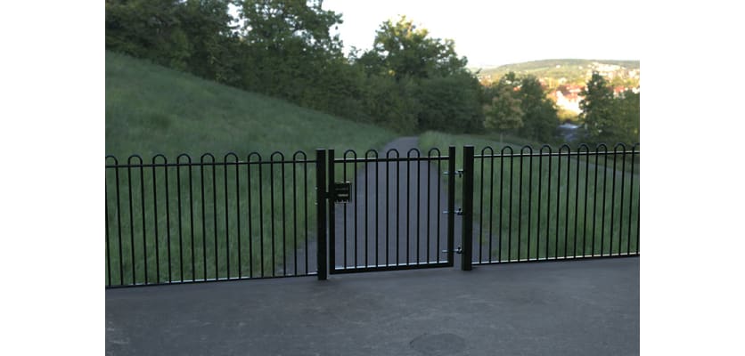 A Black Single Leaf EnviroRail® PlaySec Railing Gate securing a park 