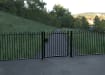 A Black Single Leaf EnviroRail® PlaySec Railing Gate securing a park 