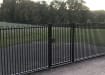 A Black Single Leaf EnviroRail® PlaySec Railing Gate securing a play field