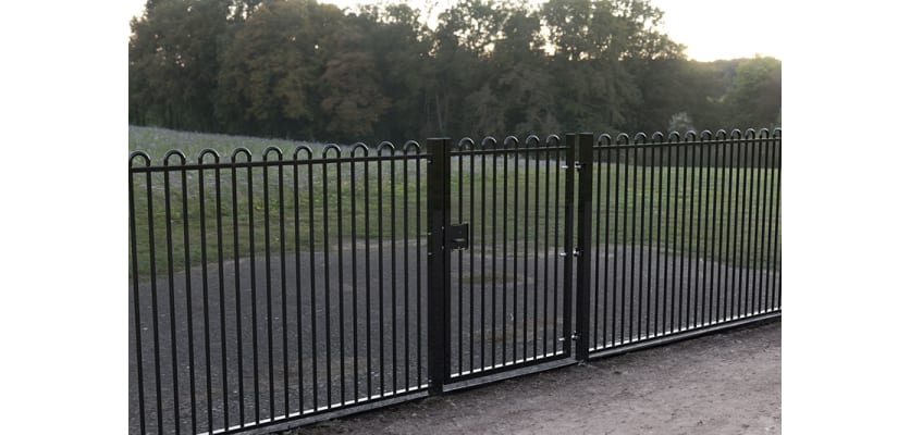 A Black Single Leaf EnviroRail® PlaySec Railing Gate securing a play field