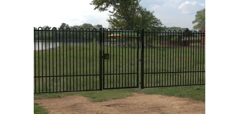 A Black Single Leaf EnviroRail® PlaySec Railing Gate securing a play field