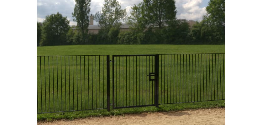A Black Single Leaf Standard Flat Top Railing Gate securing a Sports Field 
