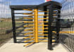 A 3 Wing Single Turnstile with Overhead Canopy near a Carpark