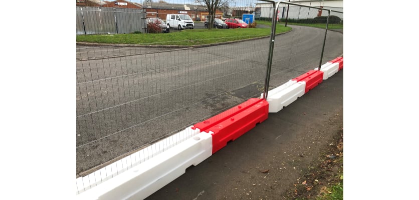 A line of Rota Slot Ballast Barriers with temporary fencing panels 