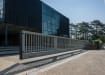 A grey FFL 95 Manual Cantilever Gate Outside an Office Building 