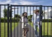 Two People about to use a Gate with a Verticlose Hydraulic Gate Closer attached 