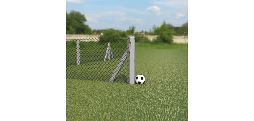 End concrete post with chain link fencing, installed on a football field, with a football next to the post