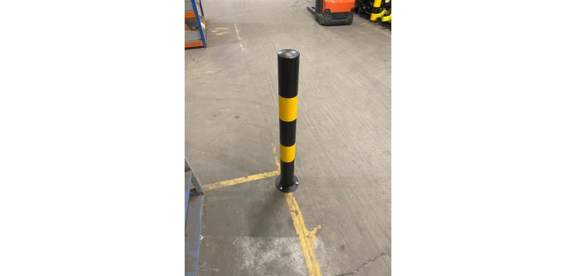 Plain yellow and black bollard installed inside a warehouse