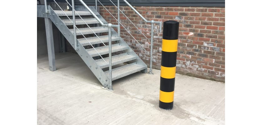 Black and yellow bollard installed near outdoor stairs