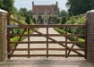 A 1.2m High Iroko Hardwood Timber Ranch Gate installed outside a large house