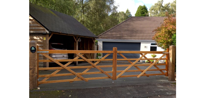 A 1.2m High Iroko Hardwood Timber Field Gate outside a house