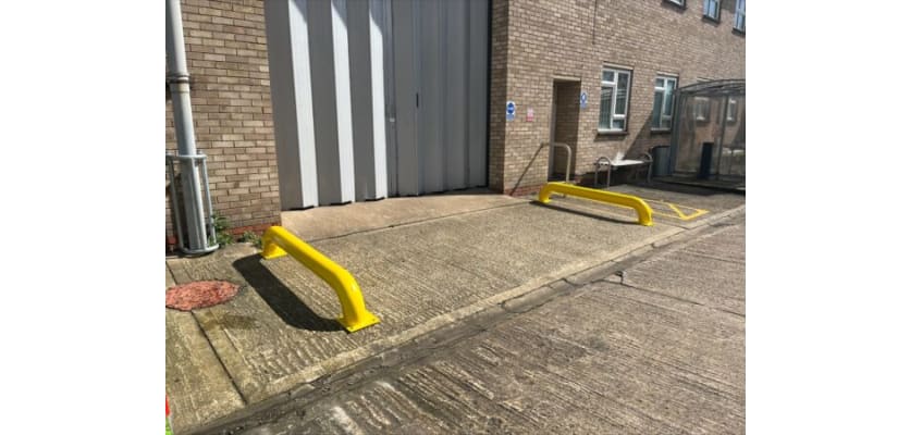 Two Yellow Galvanised Steel Wheel Guides Bolt Down outside warehouse