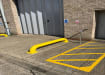 Yellow Galvanised Steel Wheel Guide Bolt Down installed outside warehouse