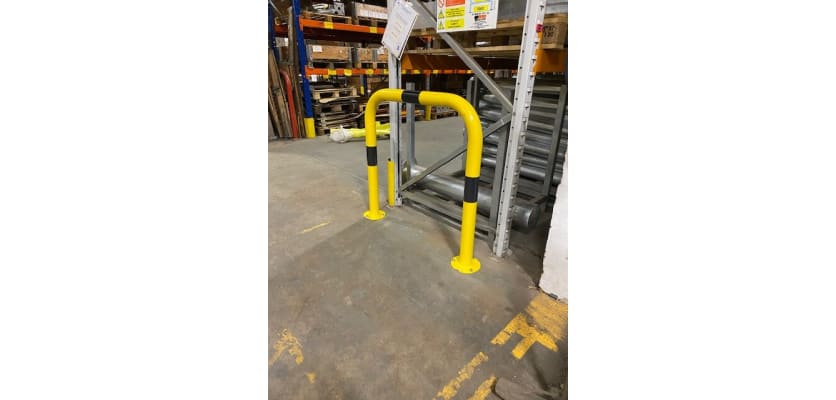 Black and yellow hooped barrier installed in a warehouse