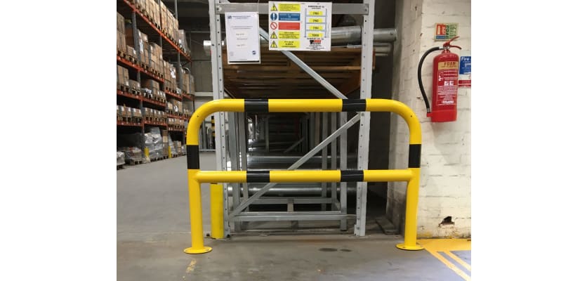 Black and yellow hooped safety barrier installed in a warehouse