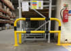 Black and yellow hooped safety barrier installed in a warehouse