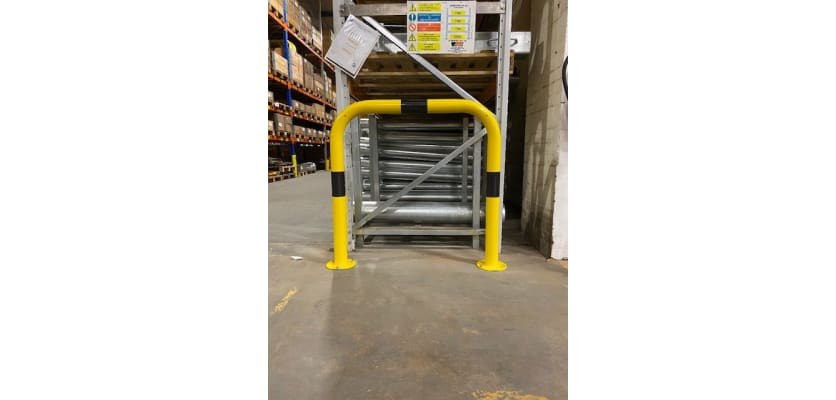 Black and yellow hooped safety barrier installed in a warehouse