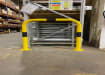 Black and yellow hooped safety barrier installed in a warehouse