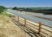 Post and rail fencing installed next to highway