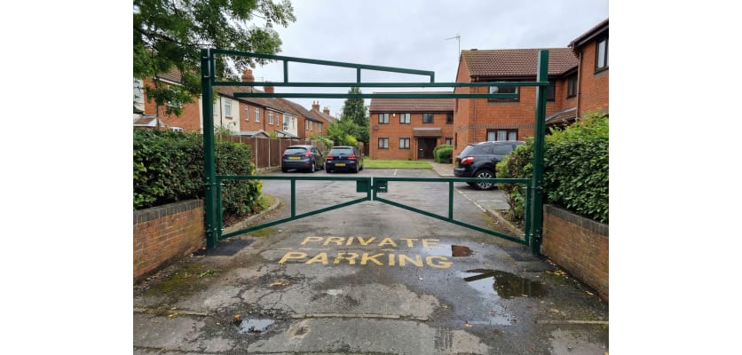 Green Double Swing Barrier with High-Level Swing Arm installed in a private car park