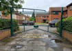 Green Double Swing Barrier with High-Level Swing Arm installed in a private car park