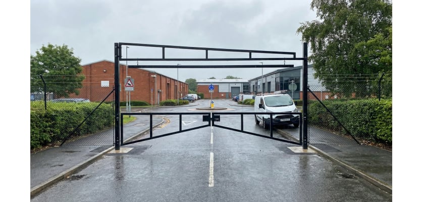 Black Double Swing Barrier with High-Level Swing Arm Kit installed at a commercial property