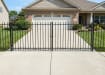 OldStead Welded Residential 2 Rail Spear Top Drive Gate installed in front of large property 