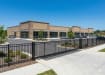 Aluminum Rackable Commercial 3-Rail Flat Top Fence Panels installed around a commercial parking lot yard.
