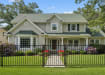A black Aluminum Residential 2-Rail Flat Top Walk Gate and matching fence panels installed as a front yard railing for a traditional suburban home.