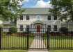 A black Aluminum Residential 3-Rail Flat Top Walk Gate and matching fence panels installed as a front yard railing for a traditional suburban home.