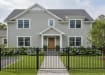 A black Aluminum Residential 3-Rail Flat Top Walk Gate and matching fence panels installed as a front yard railing for a traditional suburban home.