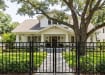 A 3-rail flat top black Aluminum Driveway Gate pair installed at the front of a residential property.