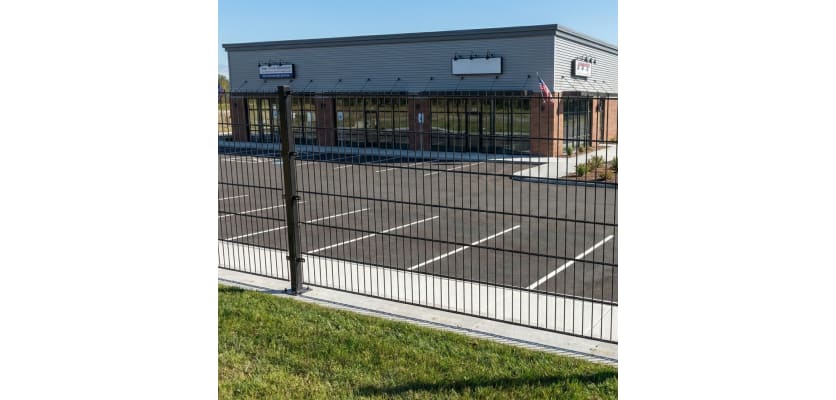 Mesh fencing with bolt-down posts, installed outside a commercial property